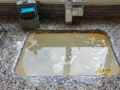 blocked drain with murky water